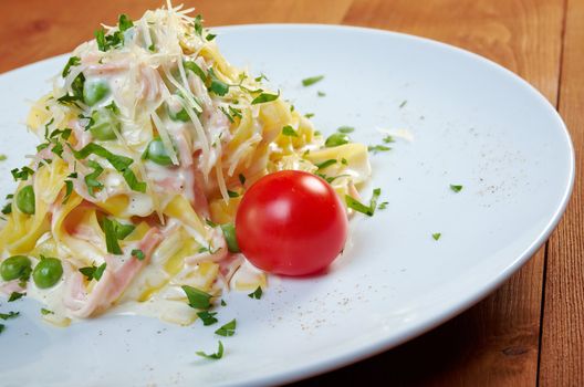 pasta Fettuccine Alfredo with cherry tomato, ham. close-up