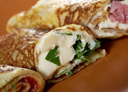 rolled pancakes stuffed ham and cheese. Shallow depth-of-field.