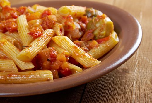 Italian Penne rigate pasta  with  vegetable  tomato sauce  on wooden table