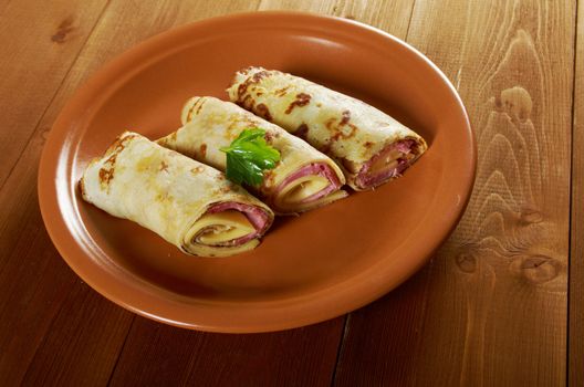 rolled pancakes stuffed ham and cheese. Shallow depth-of-field.