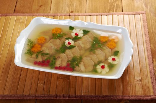 Aspic from meat decorated with egg, carrot,