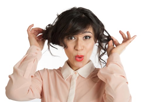 A woman in a pink blouse holds hands hair.