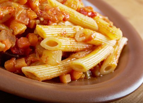 Italian Penne rigate pasta  with  vegetable  tomato sauce  on wooden table