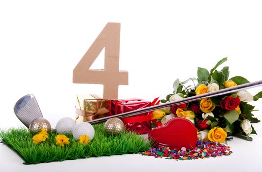 Roses, a golf club and golf balls on an artificial peace of grass to be used as a birthday card