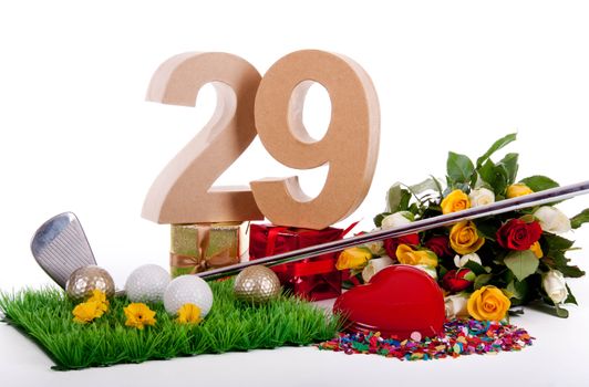 Roses, a golf club and golf balls on an artificial peace of grass to be used as a birthday card