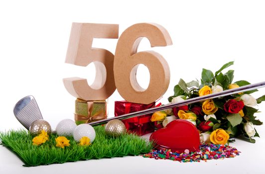 Roses, a golf club and golf balls on an artificial peace of grass to be used as a birthday card