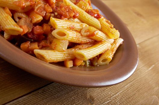 Italian Penne rigate pasta  with  vegetable  tomato sauce  on wooden table