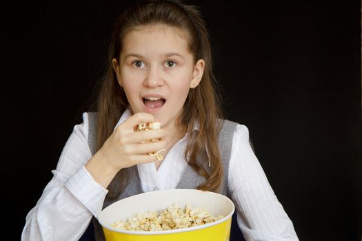 emotional girl with popcorn on a black background