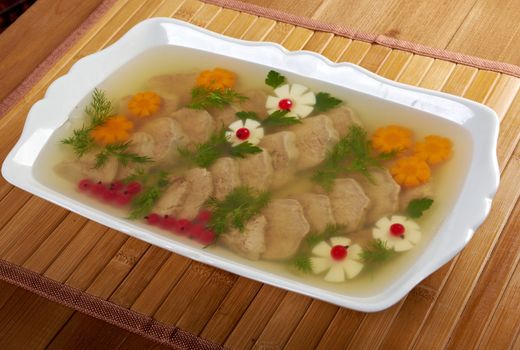 Aspic from meat decorated with egg, carrot,