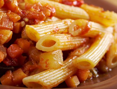 Italian Penne rigate pasta  with  vegetable  tomato sauce  on wooden table