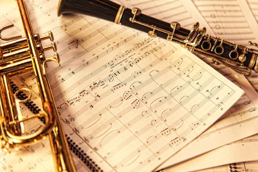Trumpet and clarinet on a background of sheet music.