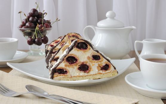 a piece of sponge cake dessert with cream cream with cherries in chocolate icing and coconut