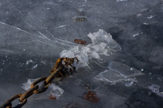 Picture of a big iron chain stuck in the ice