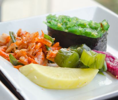 kimchi and pickled vegetable  , Chuka seaweed sush on white plate