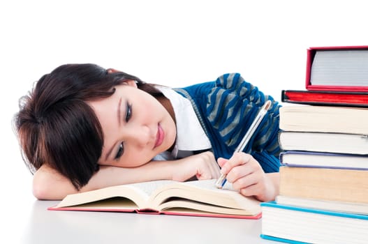 Portrait of a tired student resting on her arm while reading over white background.