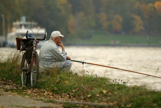 The person with a fishing tackle on a coast of the river