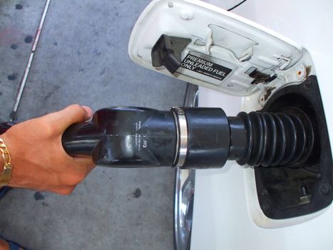 Close up of a person pumping gas.