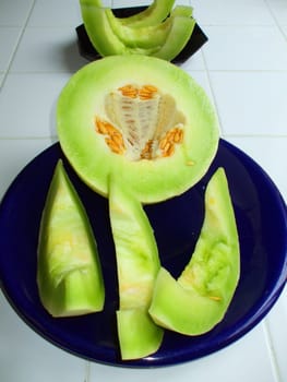 Close up of a honeydew melon on a plate.