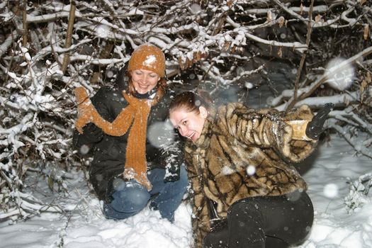 Two girls play to snow