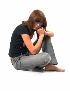 The girl in a black vest sits on a floor - a white background 
