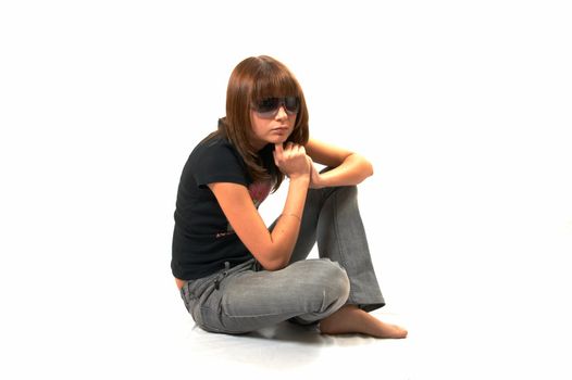 The girl in a black vest sits on a floor - a white background 