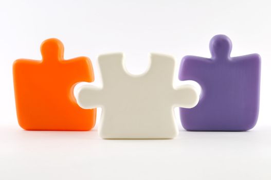 Three colorful puzzle pieces isolated on white