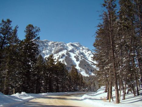 winter drive on snowy road into the Rocky Mountains