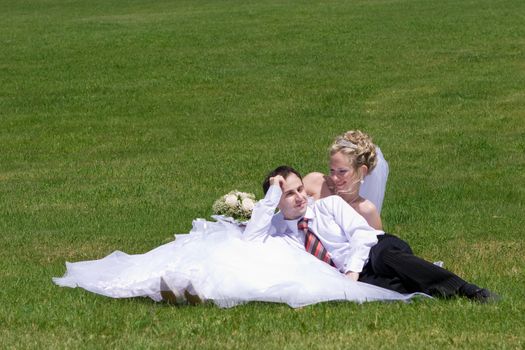 rest of newly married couple on the grass