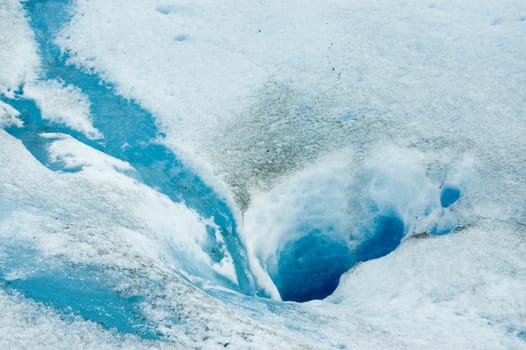 Hole in the ice carved by the water in the surface of Perito Moreno glacier, in Patagonia, Argentina.