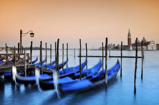Gondolas moored at the Piazza San Marco at dusk, with the Canal di San Marco and San Giorgio Maggiore church behind,Venice,Italy