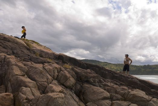 Adult couple hiking on a steep rocky mountain.