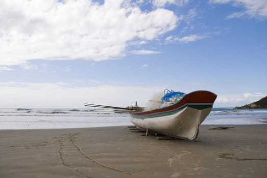 Deserted beach with empty fishing boats in the sand.