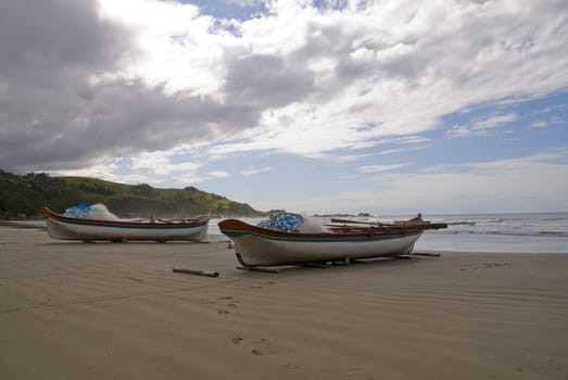 Deserted beach with empty fishing boats in the sand.