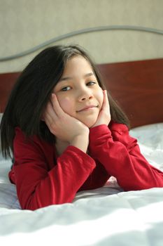 Child lying on bed thinking