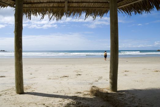 First person view of beach, shot from inside a hay shed.
