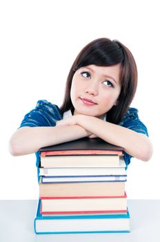 Portrait of an attractive female student resting on books and looking upwards over white background.