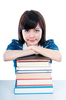 Portrait of an attractive female student resting on books over white background.