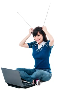 Portrait of a cute young Asian  woman with laptop and holding antennas on head over white background