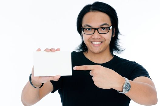 Happy young Asian man pointing to blank card over white background.
Focus on foreground.