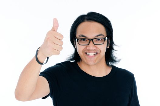 Portrait of a happy young Asian man giving thumb up sign over white background.