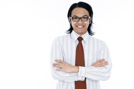 Portrait of a happy young Asian man with arms crossed over white background.