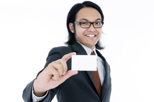 Portrait of a happy young Asian business man holding a blank name card over white bacground. Focus on the hand and card.