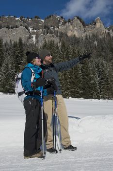 A couple  hiking on a snowy trail in val di fassa, in the dolomites