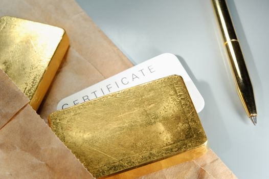 Processing and global trading of precious metals. Gold bars, certificate, pen and paper pack. Closeup.