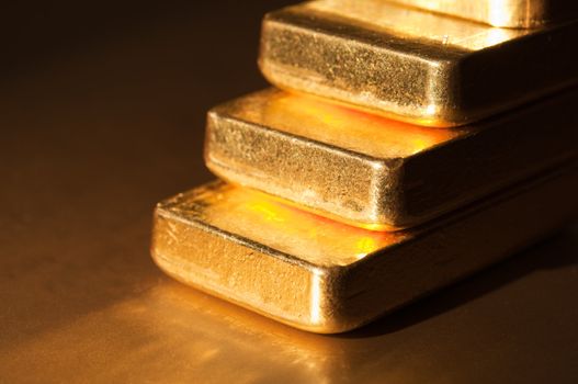 Stack fine gold ingots on a dark background. Stairs . Shallow depth of field.