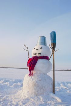 Lonely snowman at a snowy field at winter time