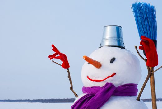 Lonely snowman at a snowy field at winter time