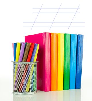 Row of colorful books and felt pens over white background