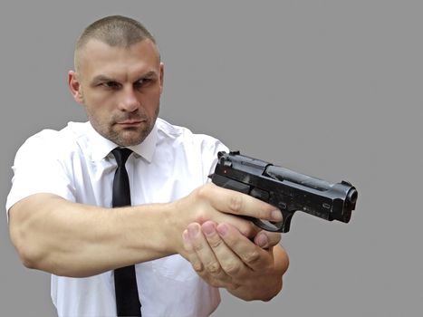 A man with a gun in his hand on a gray background