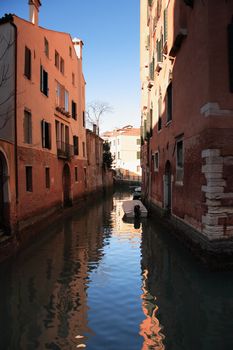 Few boats on a narrow canal between old buildings. Venice, Italy